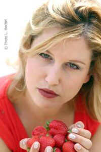 Portrait mit Schmollmund und Erdbeeren in der Hand