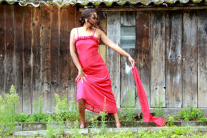 Modefoto rotes Kleid vor Holzwand
