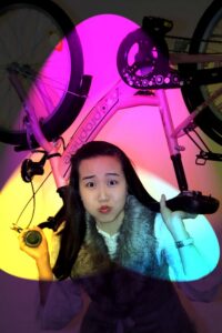 Fun Foto Mädchen stemmt Fahrrad in die Höhe